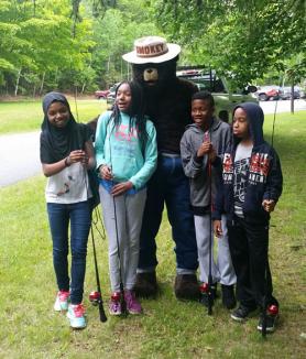 Great outdoors: Trip participants pose with Smokey Bear at the 26th Annual Forest Service/Trout Unlimited of Southwestern Vermont Youth Fishing Derby. 